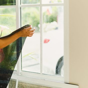 Woker wrapping tinting filma on house window using foggy spray.